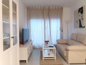 sala de estar blanca con sofá y TV en Residencial Elegance, en Denia