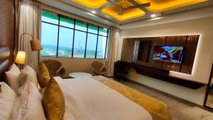 ein Hotelzimmer mit einem Bett und einem TV in der Unterkunft Four Petals Executive by LHMS in Akalkot