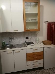 una cocina con armarios blancos y fregadero en Oasi, en Prevalle