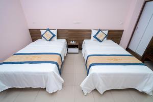 Lạng Sơn的住宿－Hoàng Sơn Hải Hotel，白色和蓝色的酒店客房内的两张床
