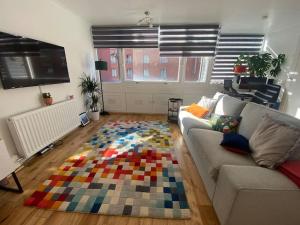 a living room with a couch and a colorful rug at 1 Bedroom apartment - City of London in London