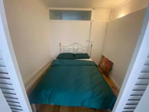 een kleine slaapkamer met een groen bed in een kamer bij 1 Bedroom apartment - City of London in Londen