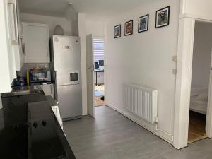 a kitchen with a refrigerator and a room with at 1 Bedroom apartment - City of London in London
