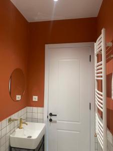 a bathroom with a white sink and a white door at Polifonia Inn Borjomi in Borjomi