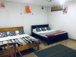 Zimmer mit 2 Betten und einem Tisch in der Unterkunft Thisara Pool Resort Kataragama & Yala & Kabiliththa Safari in Kataragama