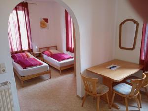 a room with a table and a bed and a table and chairs at Hotel Kremer in Büchenbeuren