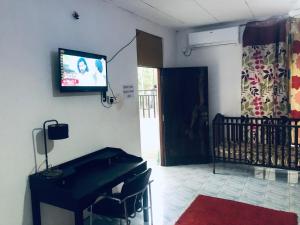 ein Wohnzimmer mit einem Klavier und einem TV an der Wand in der Unterkunft Thisara Pool Resort Kataragama & Yala & Kabiliththa Safari in Kataragama