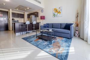 a living room with a blue couch and a table at Awesome Marina Canal View 1BD Bay Central Marina in Dubai