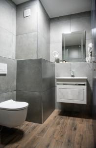 La salle de bains est pourvue de toilettes blanches et d'un lavabo. dans l'établissement Hotel Beograd Struga, à Struga