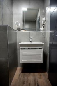 ein Bad mit einem Waschbecken und einem Spiegel in der Unterkunft Hotel Beograd Struga in Struga