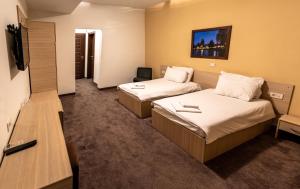 a hotel room with two beds and a tv at Hotel Beograd Struga in Struga