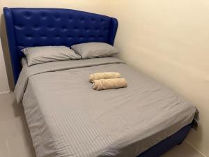 Una cama con una cabecera azul con un animal de peluche. en 4 Bedroom Bungalow, Angeles City, en Ángeles