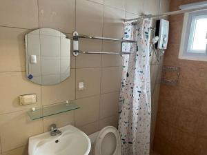 La salle de bains est pourvue de toilettes, d'un lavabo et d'un miroir. dans l'établissement 4 Bedroom Bungalow, Angeles City, à Ángeles