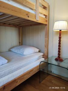 a bedroom with a bunk bed with a lamp and a glass table at Nordgards Hagen in Lillehammer