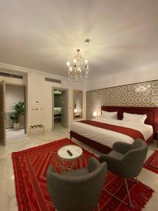 a bedroom with a bed and two chairs and a chandelier at La Menara Hotel & SPA in Sidi Bou Saïd