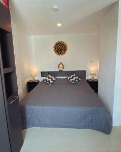 ジョムティエンビーチにあるTrio Gems Condo Pattaya, Thailandの大きなベッドと2つのナイトスタンドを備えた寝室