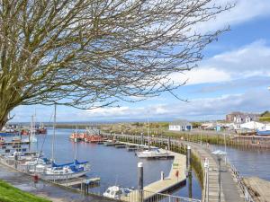 a marina with boats docked in the water at Miners Cottage in Girvan