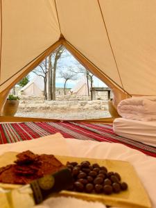 une tente avec une assiette de nourriture et un couteau dans l'établissement KARMEI NEGEV - מתחם גלמפינג ואטרקציות מבית גלובל גלמפינג, à Mitzpe Ramon
