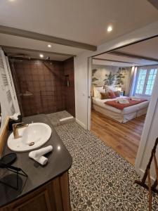 a bathroom with a sink and a bedroom with a bed at Au Moulin Saint Nicol - Honfleur in Honfleur