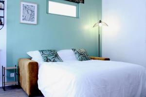1 dormitorio con 1 cama blanca y 1 lámpara en NATURE, en Cosne-Cours-sur-Loire