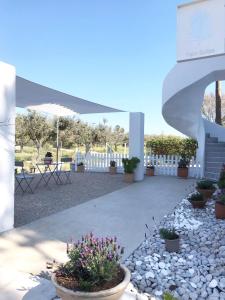 a patio with potted plants and a white fence at Palm Suite Green in Porto Heli