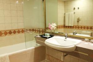 y baño con lavabo, ducha y bañera. en Al Manar Grand Hotel Apartment, en Dubái