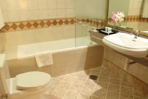 a bathroom with a toilet and a sink and a tub at Al Manar Grand Hotel Apartment in Dubai