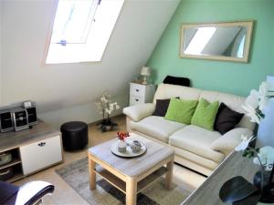 a living room with a white couch and a table at Ferienwohnungen/Ferienzimmer Seidel in Zingst