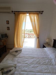 a bedroom with a large bed and a window at Socrates in Elafonisos