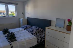 a bedroom with a bed and a dresser and a window at Luxe Chalet Strubben-Kniphorstbos Anloo in Anloo