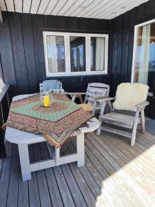 mesa y 2 sillas en una terraza con mesa en Nordgards Hagen en Lillehammer