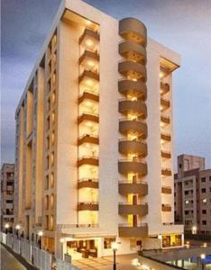 ein großes weißes Gebäude mit gelben Lichtern in der Unterkunft Cocoon Hotel in Pune
