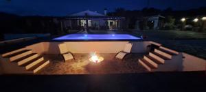 una piscina por la noche con fuego en el medio en B&B Casa Loré D'or en Alora
