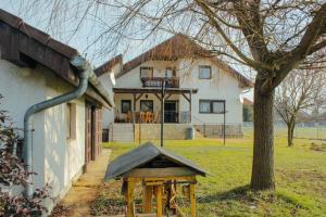 a bird house in front of a house at ZOLI'BÁ Apartman in Gyöngyösfalu