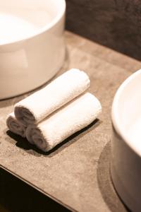 una pila de toallas sentadas en un mostrador junto a un fregadero en Anasa Luxury Resort, en Elaiokhórion