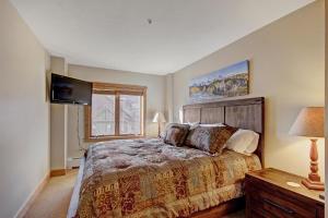 um quarto com uma cama grande e uma televisão de ecrã plano em Red Hawk Lodge 2298 em Keystone