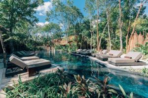 a swimming pool with chaise lounge chairs in a resort at Hotel Bardo - Adults Only in Tulum