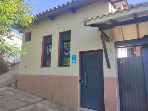 a house with a blue door and two windows at la casa de las cabilas in Cuevas del Valle