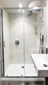 W łazience znajduje się prysznic i umywalka. w obiekcie 11 Putsborough - Luxury Apartment at Byron Woolacombe, only 4 minute walk to Woolacombe Beach! w mieście Woolacombe