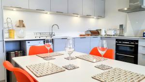 una cucina con tavolo e bicchieri da vino di 11 Putsborough - Luxury Apartment at Byron Woolacombe, only 4 minute walk to Woolacombe Beach! a Woolacombe