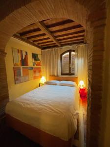 ein Schlafzimmer mit einem großen weißen Bett mit zwei Lampen in der Unterkunft The Small Sweet House in Montepulciano