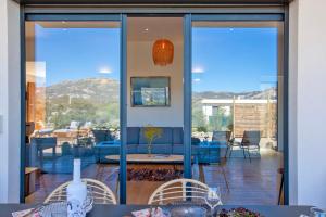 a dining room with a view of a patio at Villa avec piscine bbq pétanque Calme à 5km de la plage de sable de Calvi in Calenzana