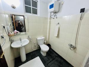 a bathroom with a white toilet and a sink at Embrace "The Fine Stay" in Nuwara Eliya