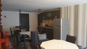 a kitchen with tables and chairs and a refrigerator at Pensiunea Paula in Moieciu de Sus