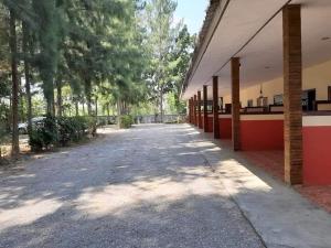 an empty street next to a building with trees at คีรีเฮ้าส์ in Ban Nong Bua
