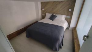 ein kleines Schlafzimmer mit einem Bett in einem Zimmer in der Unterkunft vivienda turística los Robles in Tudela
