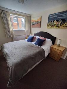 a bedroom with a large bed with blue pillows at Stunning 1 bedroom apartment over looking river in Rye