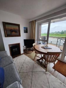 a living room with a couch and a table at Stunning 1 bedroom apartment over looking river in Rye