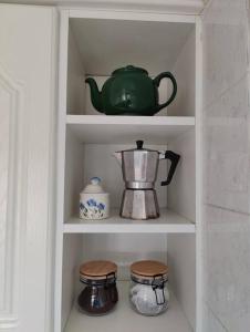 a cupboard with a tea pot and other items in it at Stunning 1 bedroom apartment over looking river in Rye