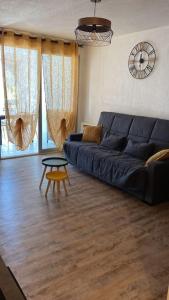 a living room with a blue couch and a table at T2 tout équipé floralie 2 in Le Grau-du-Roi